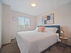 a bedroom with a large bed with a clock on the wall at 1mile To Arenagonzagaetc Wd, Off St Parking in Spokane