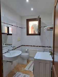 biała łazienka z umywalką i toaletą w obiekcie Casa Alessandra w mieście Àrbatax