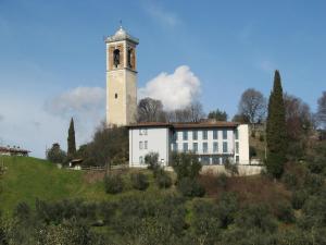 a white building with a clock tower on a hill at B&B Dolce Risveglio in Puegnago