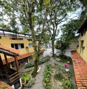a courtyard of a building with trees and plants at Pousada Boiçucanga in São Sebastião +14 photos