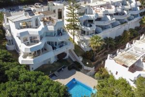 an aerial view of a large white building with a swimming pool at Relaxing Family Retreat with Stunning Golf Views in Benalmádena