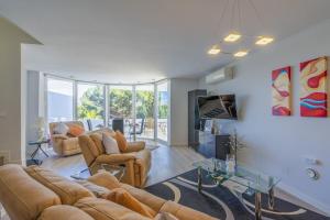 a living room with two couches and a tv at Relaxing Family Retreat with Stunning Golf Views in Benalmádena
