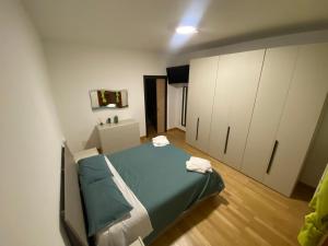 ノヴァーラにあるMisani Apartmentsのベッドとキャビネットが備わる小さな客室です。