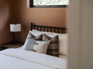 a bedroom with a bed with pillows and a window at Cutthroat Trout Cabin Near Trails Hike and Bike in Grant