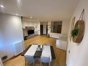 ノヴァーラにあるMisani Apartmentsのテーブルと椅子のあるダイニングルームとリビングルーム