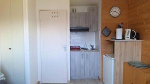 Una cocina con refrigerador y un reloj en la pared. en Résidence Podium - POD708 STUDIO 4 PERSONNES STATION 1600 MAE-0223, en Puy-Saint-Vincent
