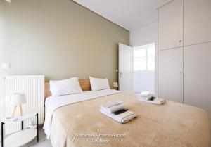 a bedroom with a large bed with towels on it at Nathaniel Athens Airport in Spata