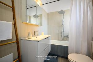 a bathroom with a sink and a toilet and a tub at Nathaniel Athens Airport in Spata