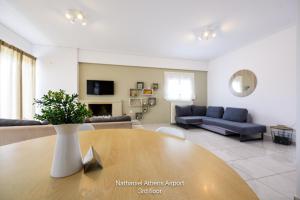 a living room with a table and a couch at Nathaniel Athens Airport in Spata +53 photos