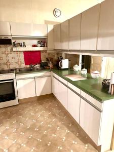 a kitchen with white cabinets and green counter tops at Payerbah cottage in Größing +7 photos