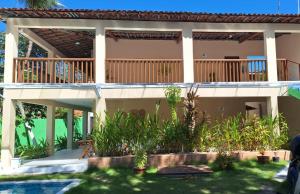 a house with a deck and a swimming pool at Caminho do Paraíso in Porto De Galinhas