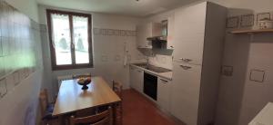 a small kitchen with a wooden table and a table and chairs at Casa Galet in Pieve Di Ledro