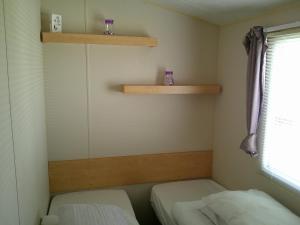 a small room with two beds and shelves at Promenade Vacation PR 8 Berth Access to the beach in Ingoldmells