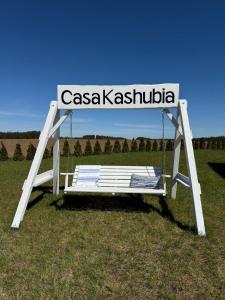 a swinging bench with a sign that reads casasha ashushima at Casa Kashubia - Kaszuby Domek nad jeziorem I cisza natura i luksus in Brzeźno Szlacheckie