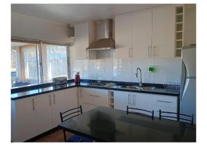 una cucina con mobili bianchi e un piano di lavoro nero di Casa CrisLuz a Pinto