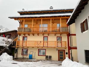Un gran edificio de madera con un balcón. en Appartamento Cima 12, en Pozza di Fassa