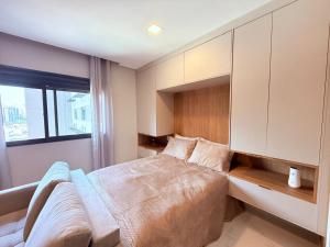 a bedroom with a large bed and a cabinet at Studio Prime - Vila Olímpia in Sao Paulo