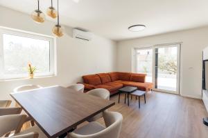 a living room with a couch and a table and chairs at Martha's Oliveyard in Biograd na Moru