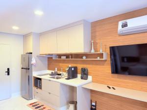 a kitchen with a sink and a tv and a counter at Studio Prime - Vila Olímpia in Sao Paulo