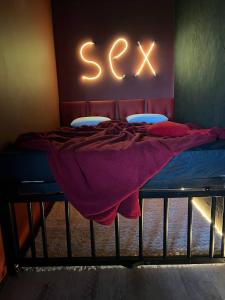 a bed in a room with a sign that says sex at Lust&Desire BDSM Krakow Apartment in Kraków