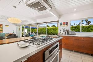 a kitchen and living room with a stove top oven at Alexander Escape - Historic Alexander Home in Palm Springs