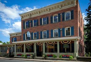 a red brick building with blue shuttered windows at Six Bells Countryside Inn in Rosendale