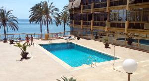 una piscina frente a un hotel con el océano en Luxury Studio, en Marbella