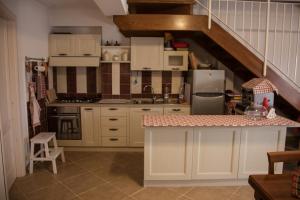 a kitchen with white cabinets and a spiral staircase at Il Vicoletto B&B in Alfedena