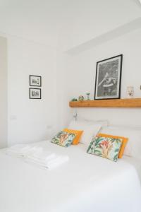 a white bedroom with two pillows on a bed at Dimora Storica Villa Pasquale Capri in Capri