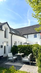 eine Terrasse mit 2 Stühlen und einem Tisch vor einem Haus in der Unterkunft Deluxe Apartement mit Terrasse in Duisburg