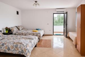 una camera d'albergo con due letti e un divano di Apartments Lejla a Dobra Voda Altre 23 foto