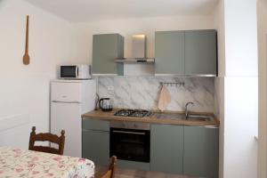 a kitchen with a sink and a stove and a refrigerator at casa mare monti in Lago