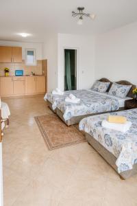 una camera con tre letti e una cucina di Apartments Lejla a Dobra Voda
