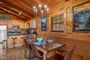 a dining room with a table and chairs in a cabin at Mtn Views, Hot Tub, Sauna, EV, Arcade! in Gatlinburg