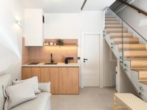 a living room with a staircase and a kitchen at NOEMA suites in Preveza