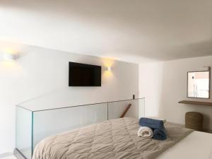 a bedroom with a bed with a tv on the wall at NOEMA suites in Preveza