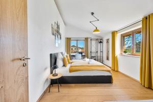 a bedroom with a king sized bed and yellow curtains at CHALET AM SEE - Seeblick Bergblick modern charmant NEU in Seeon-Seebruck