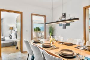 a dining room with a wooden table and chairs at CHALET AM SEE - Seeblick Bergblick modern charmant NEU in Seeon-Seebruck