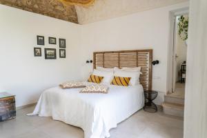 a bedroom with a white bed with two pillows on it at Dimora Storica Villa Pasquale Capri in Capri