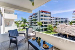 a balcony with chairs and a table and a building at Puertarena in Nuevo Vallarta