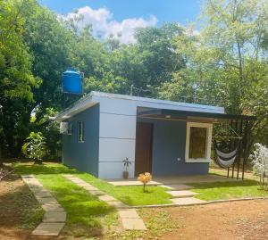 a small blue and white house in a yard at Quinta el Refugio in Masaya