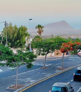 una strada con auto parcheggiate su una strada con alberi di Ideal for Families-Children's Play Area, Terrace, BBQ, WiFi a San Isidro