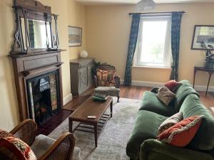 a living room with a green couch and a fireplace at Southsea, Portsmouth - Two Bedroom Apartment - Newly Refurbished Throughout - Treetop Sea Views in Portsmouth