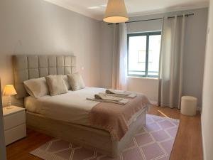 a bedroom with a large bed and a window at Lovely&Cozy apartment in Lagoa
