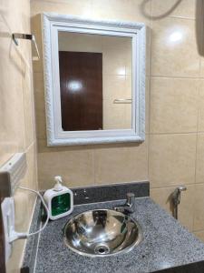 a bathroom with a sink with a clock on the counter at Casa Zago 2 in Santa Maria Madalena +20 photos
