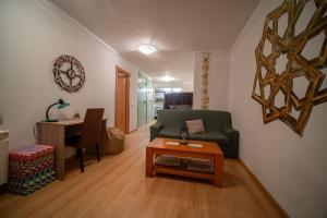 a living room with a green couch and a table at Las Torres 2 in Calatayud