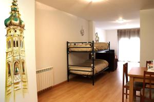 a room with two bunk beds and a dining room at Las Torres 2 in Calatayud