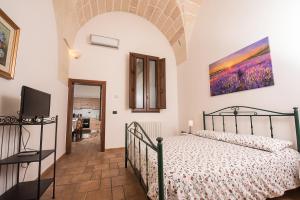 1 dormitorio con 1 cama y TV en la pared en Appartamenti "Il Delfino", en Lecce