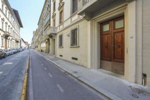 an empty street with buildings and a wooden door at Modern Comfort in Florence in Florence