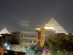 a view of the pyramids of egypt at night at Malek Pyramids Guest House in Cairo